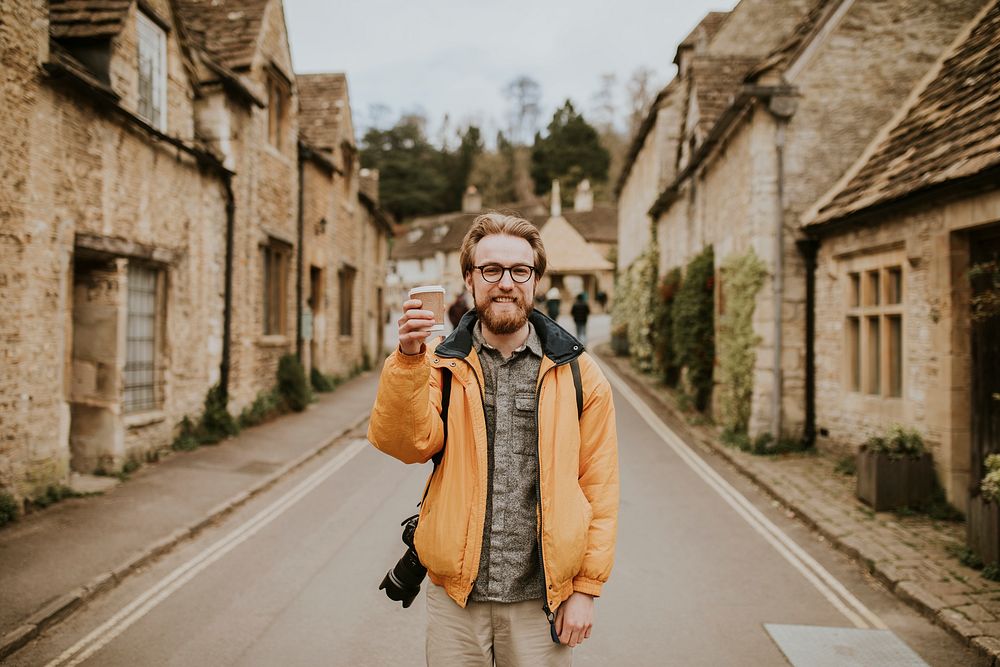 Tourist holding coffee cup smiling in the village