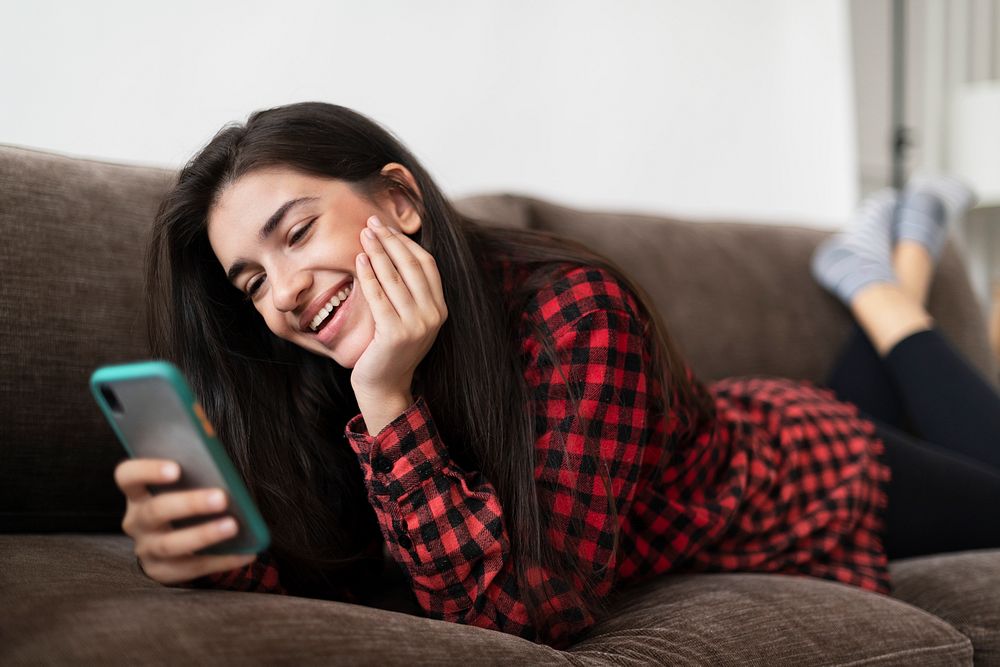 Happy woman video calling on a phone in the new normal