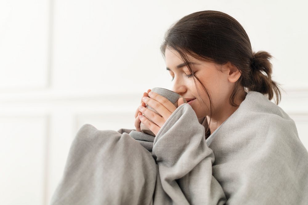 Woman taking a sip of tea from the mug during winter
