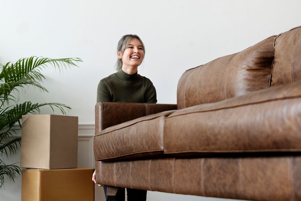 Woman moving a sofa in a new home