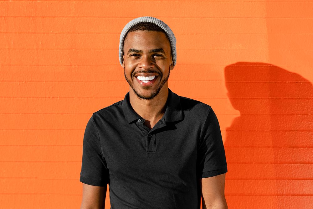 Happy African American man, orange wall background
