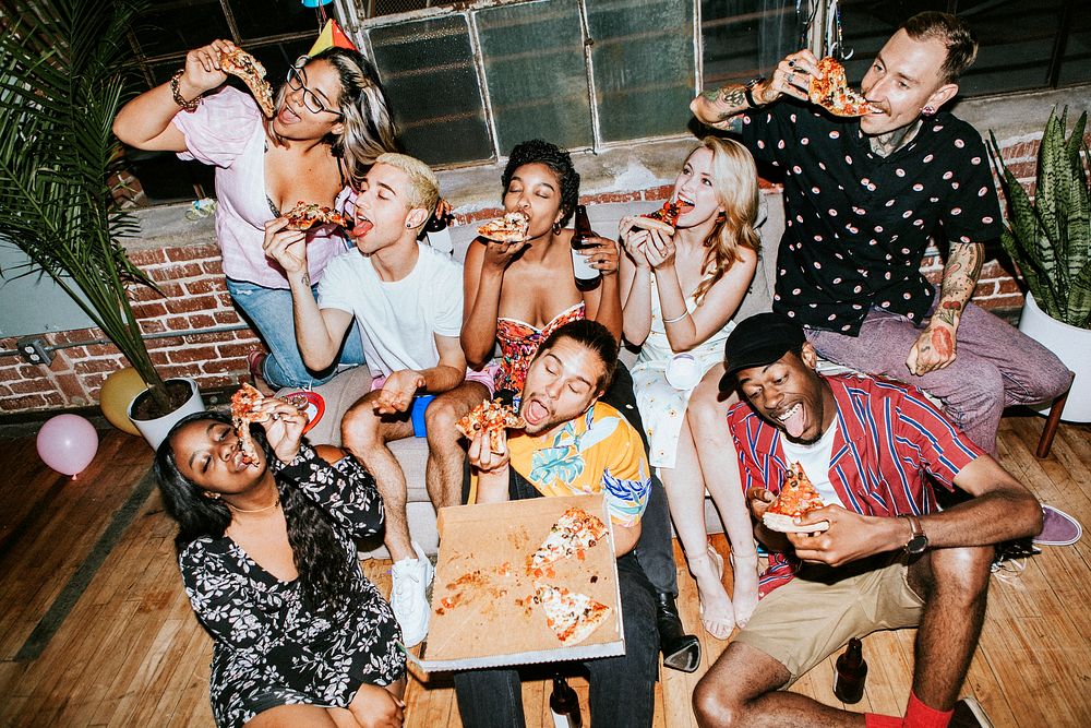 A group of diverse friends enjoying pizza  at a party