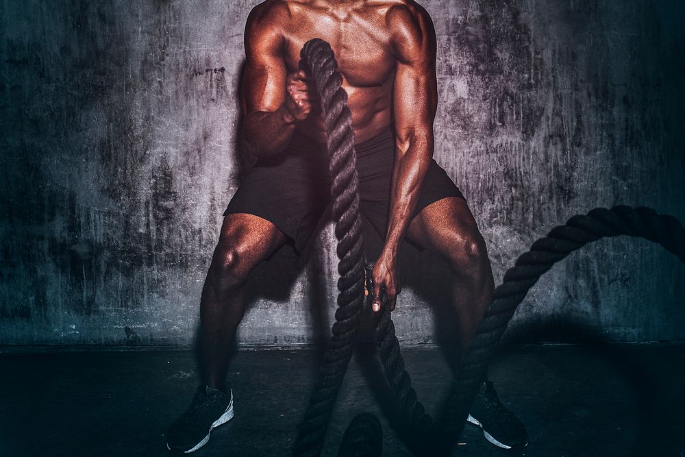 Strong man creating waves with battling ropes