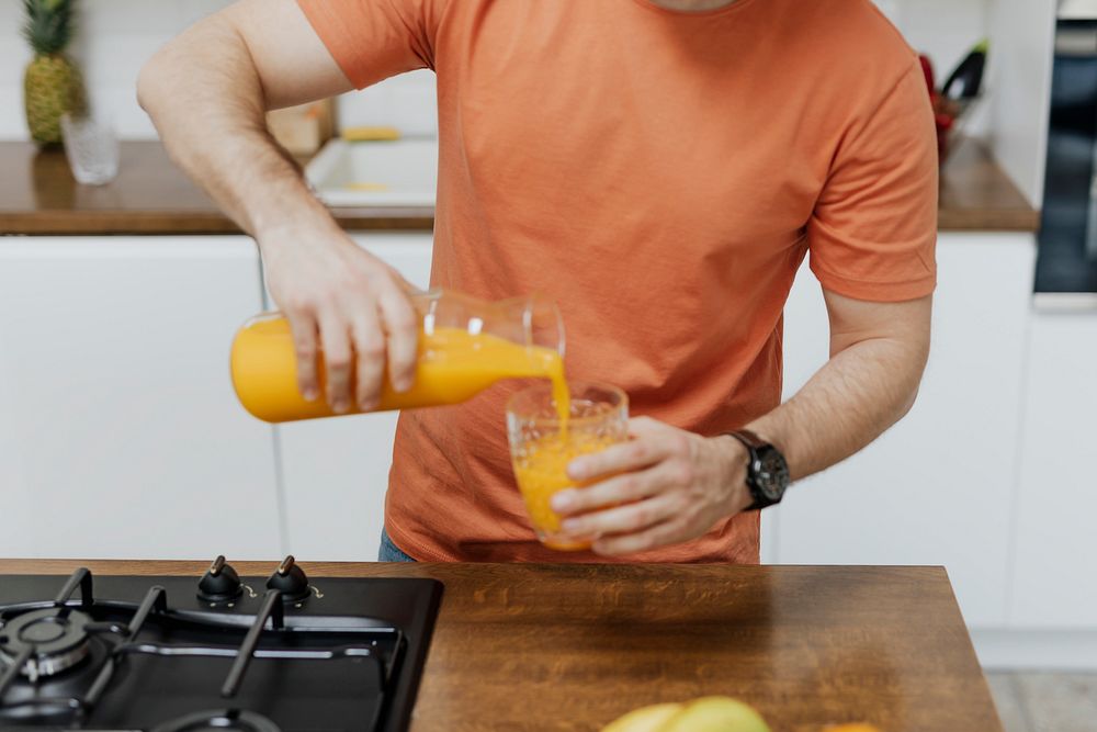 Man pouring orange juice into a glass