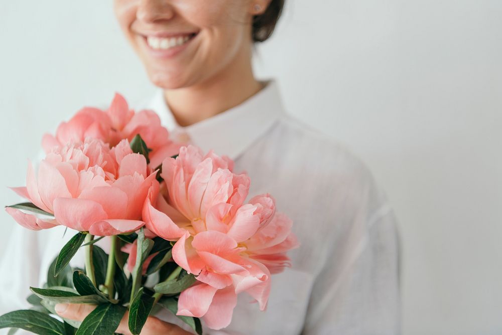 Happy woman holding a bouquet of peonies