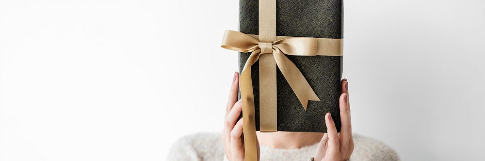 Woman covering her face with a gray present