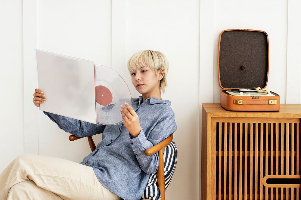 Asian woman sitting on a chair holding a vinyl record