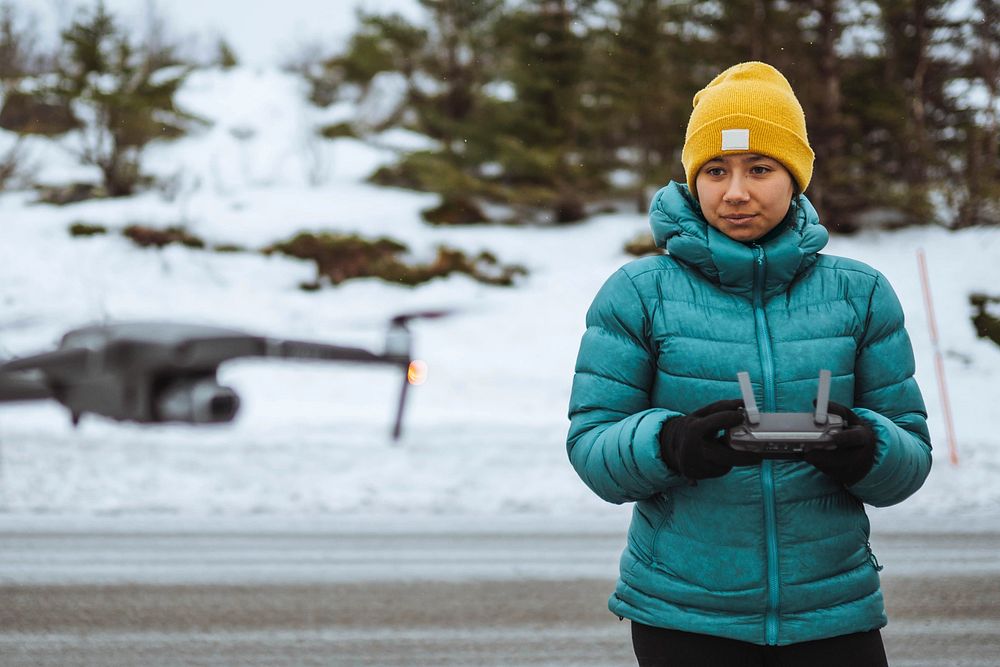 Woman flying a drone in Lofoten, Norway