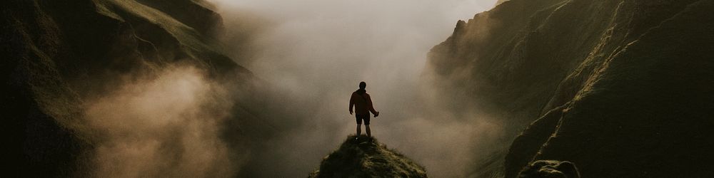 Man standing on a misty cliff banner