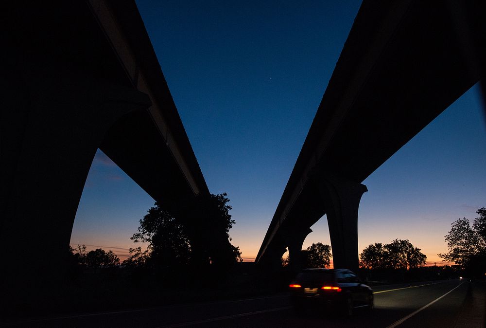 Highway overpass that crosses the Sacramento River, and through California farm land during sunset, near Sacramento, CA, on…