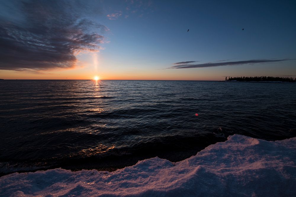 Sunrise over Lake Superior at Grand Marais, MN is one of many cities that visitors stay when enjoying winter recreation…