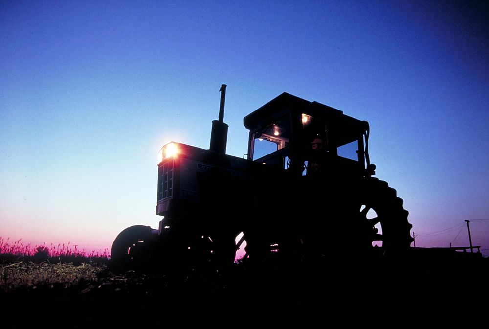 sun rising behind tractor. Original public domain image from Flickr