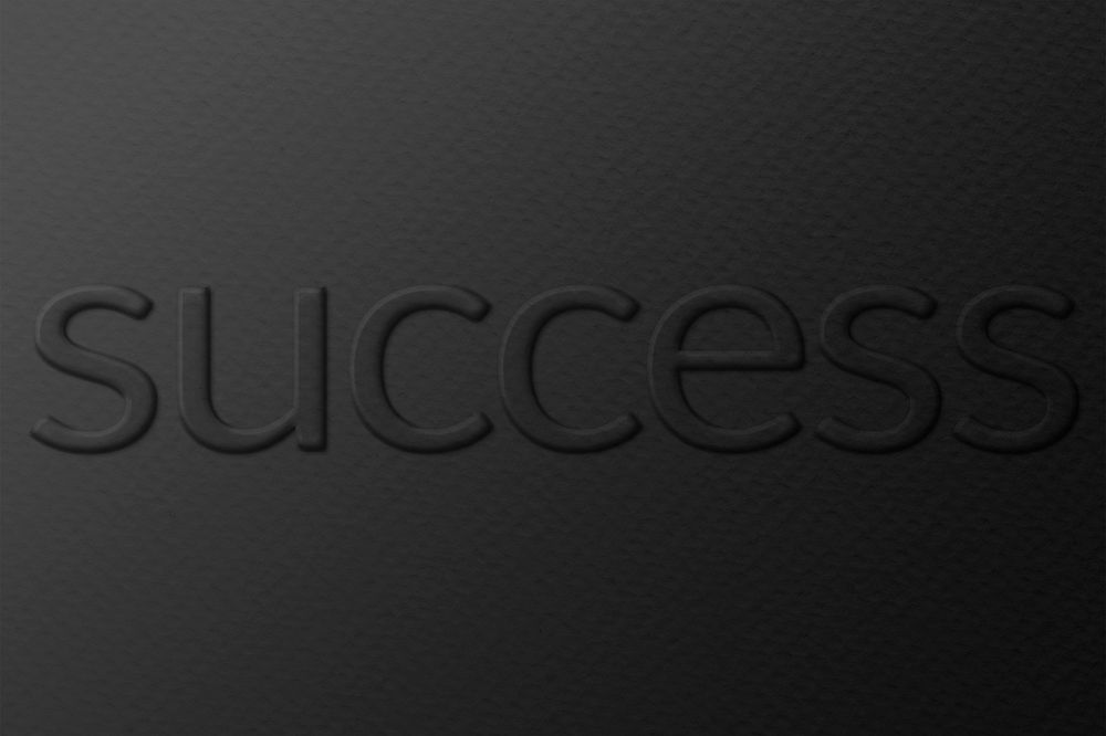 Success word embossed typography on paper texture