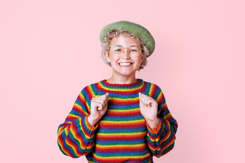 Happy girl wearing colorful knitwear, pink background
