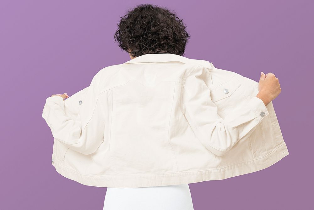 Girl wearing white denim jacket, back view, purple background