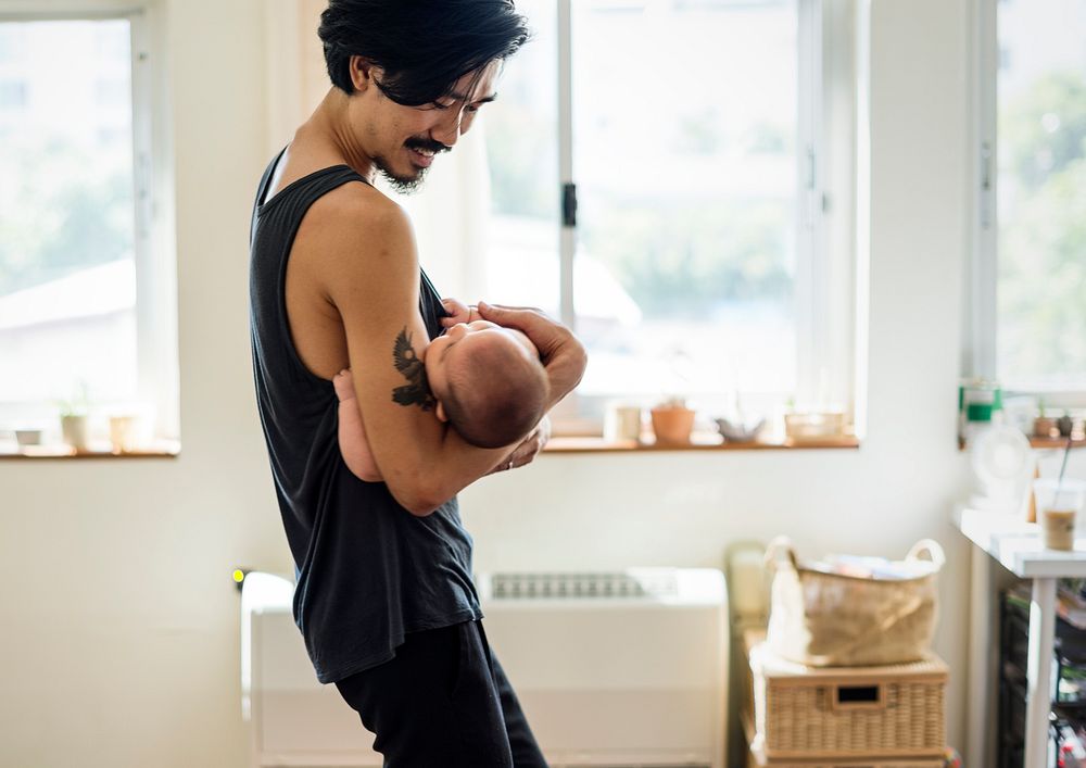 Happy Asian dad holding his baby in his arms