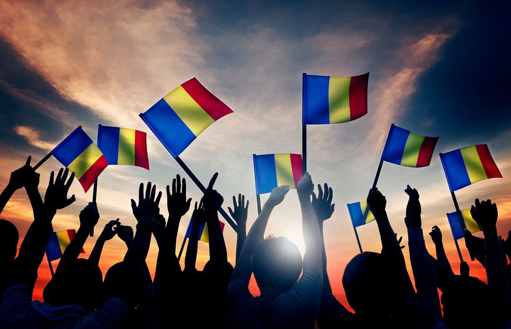 Group of People Waving Romanian Flags in Back Lit