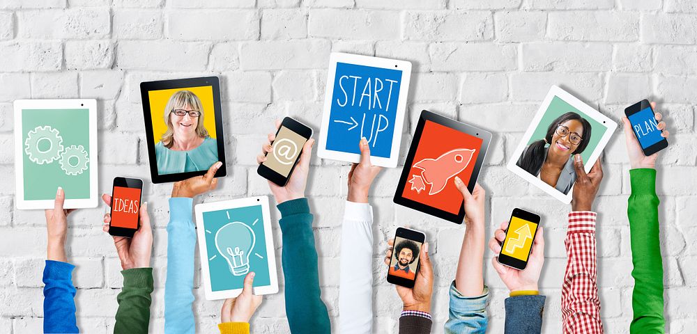 Group of Hands Holding Digital Devices with Startup Concept