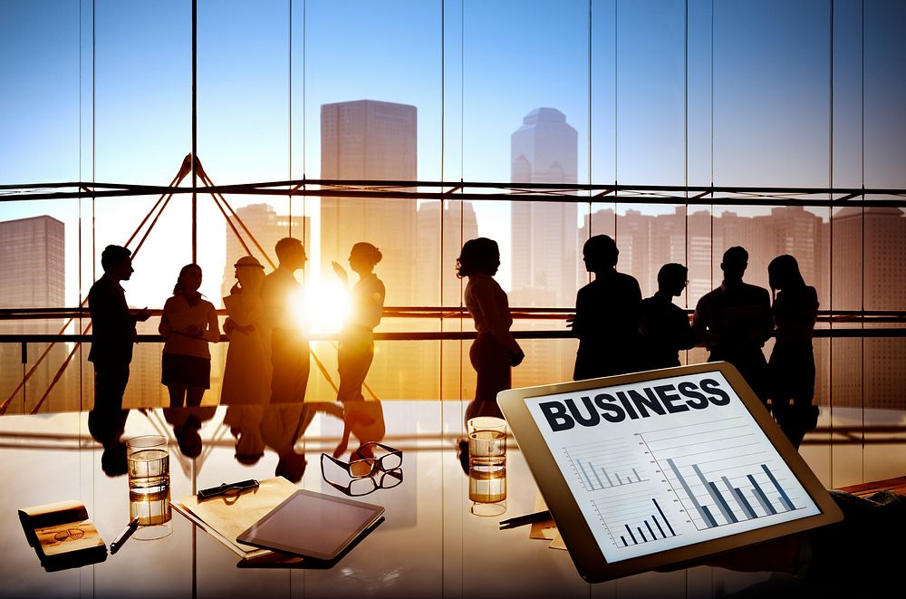 Silhouettes Of Multi-Ethnic Group Of Business People Working Together In A Board Room