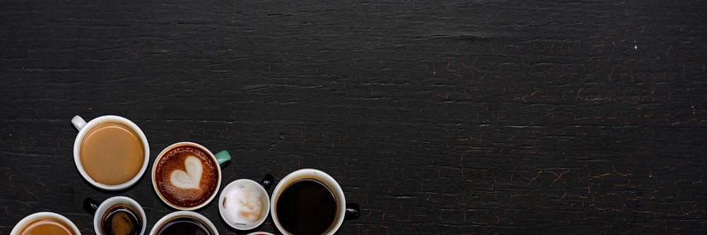 Coffee mugs on a black wooden surface with design space