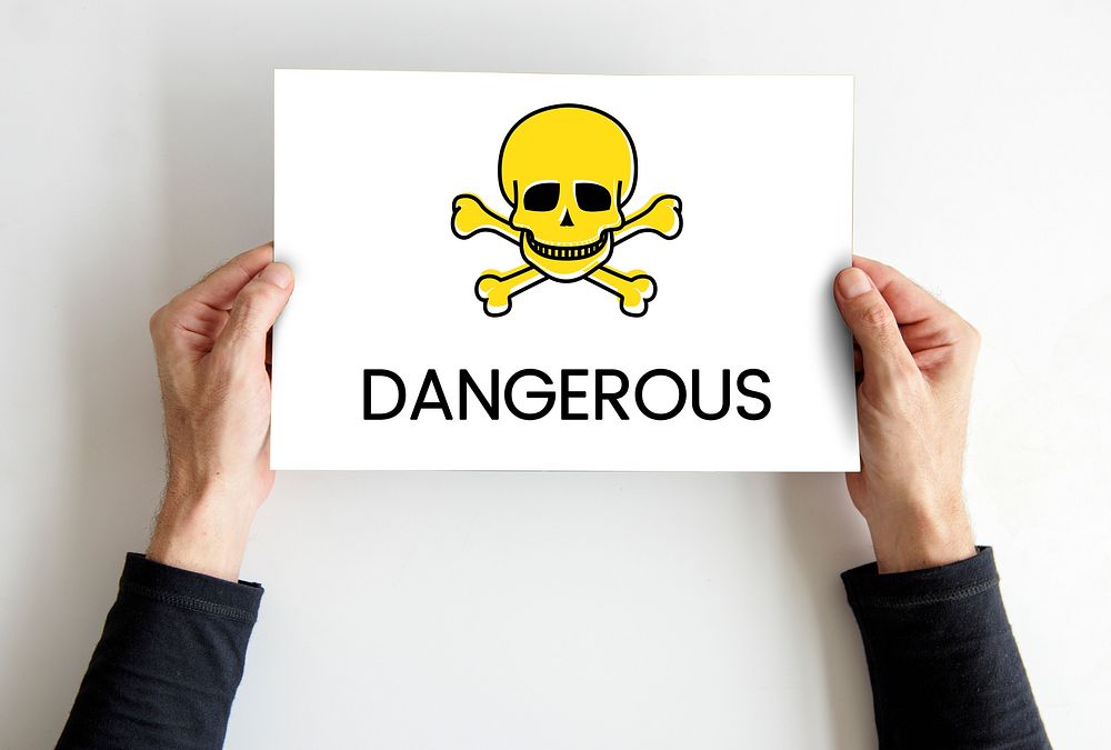 Hands holding placard skull icon and toxin dangerous word