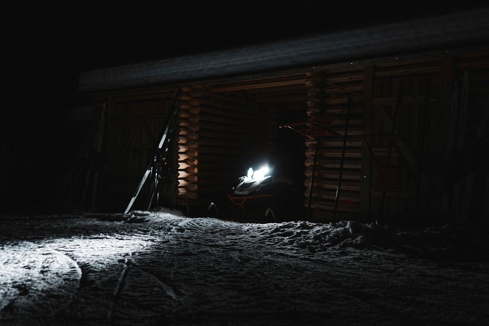 Parked snowmobile in a cabin at night