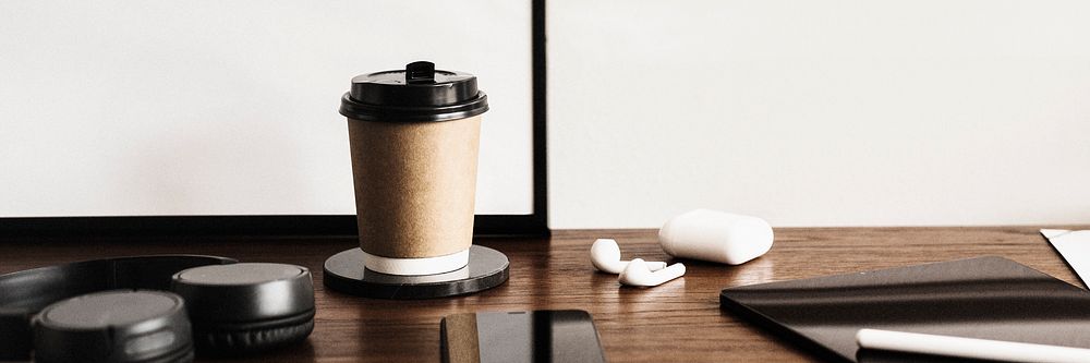 Coffee cup and a digital tablet on a wooden desk