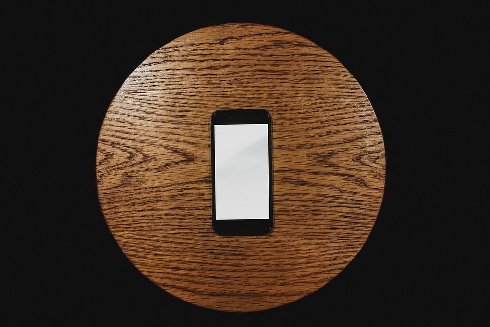 Mobile phone screen mockup on a wooden table