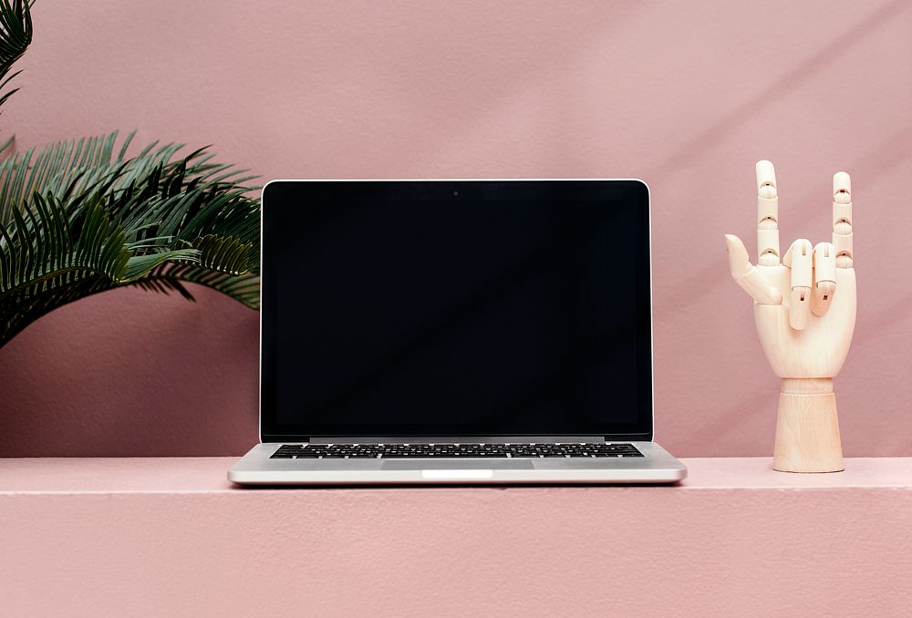 Blank laptop on a pink minimal background and table
