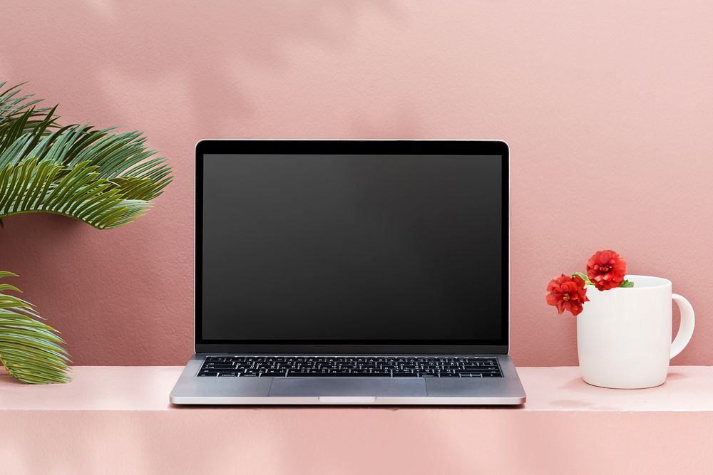 Blank laptop on a pink minimal background and table