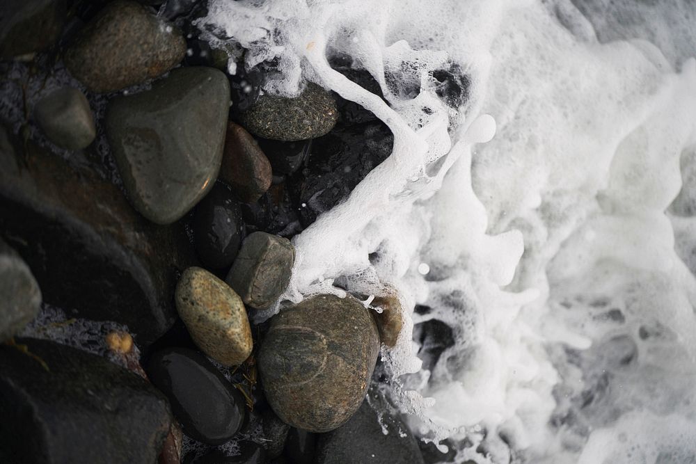 Foamy wave on a rocky shore at Isle of Skye, Scotland