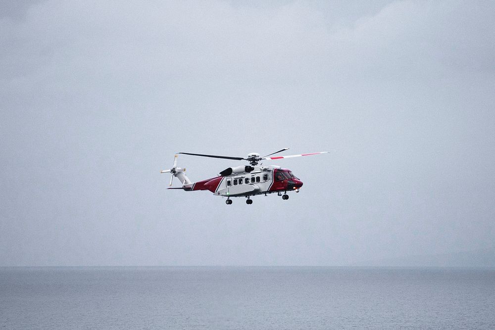 Coastguard helicopter flying over the sea in Scotland