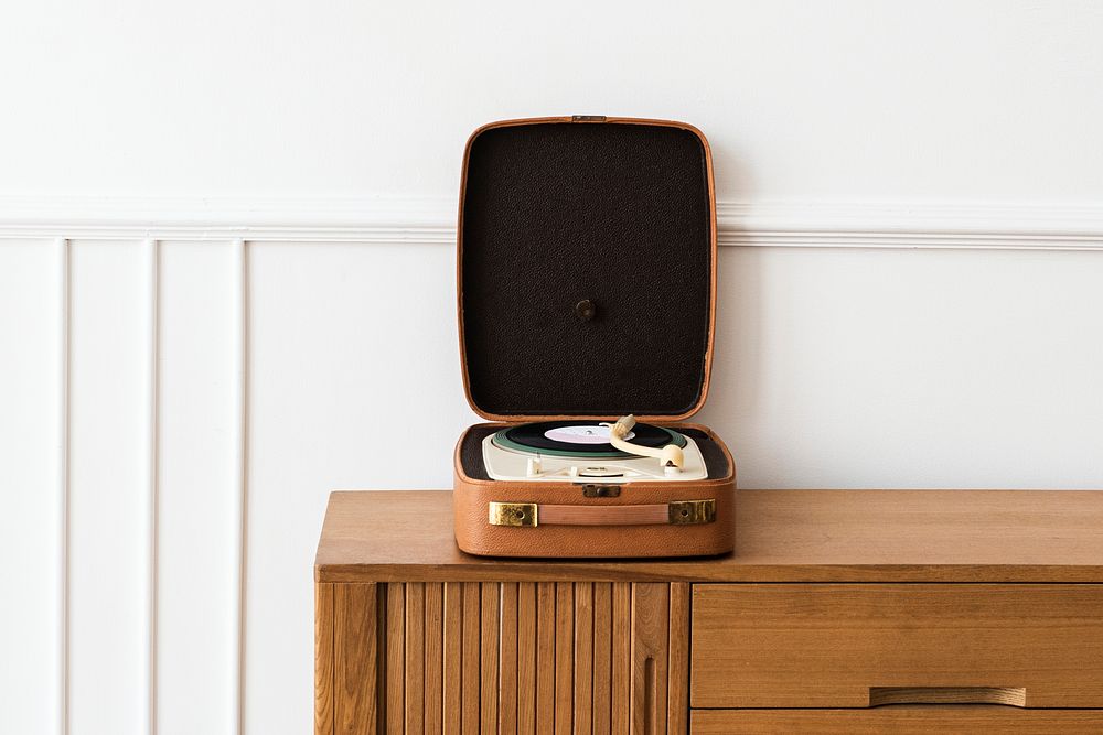 Vinyl player in a portable turntable on a wooden sideboard table 