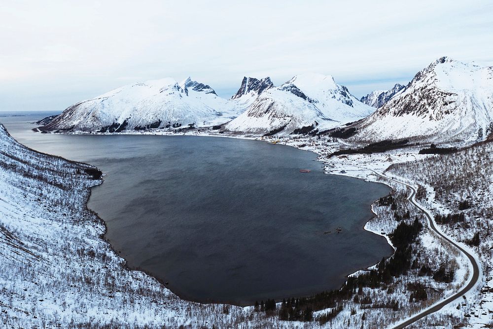 Drone shot of snowy mountains in Norway indented with fjords 