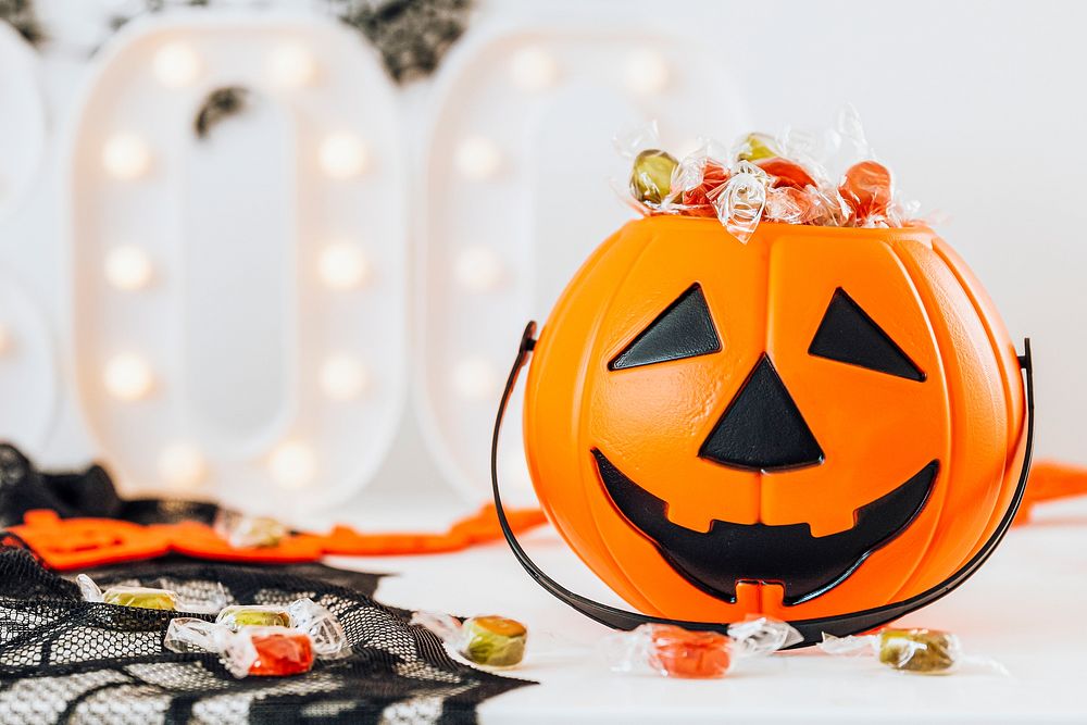 Halloween home decoration with a pumpkin basket filled with candies 