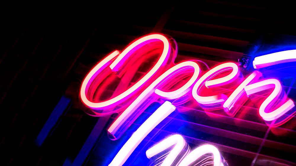 Neon pink open sign on black background