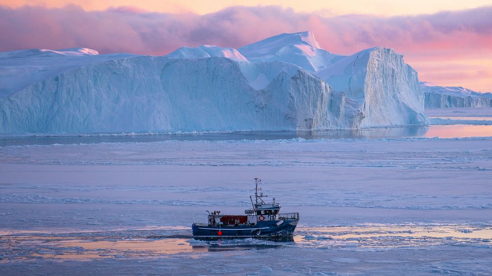 Ice breaker crushing through the frozen sea in the early morning on Greenland