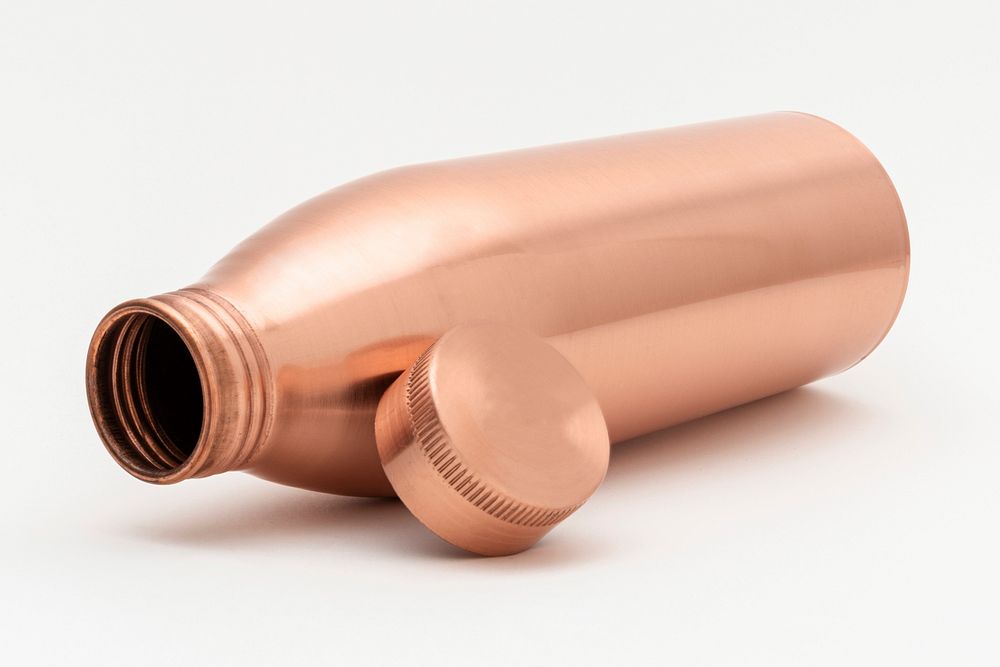Copper water bottle on an off white background
