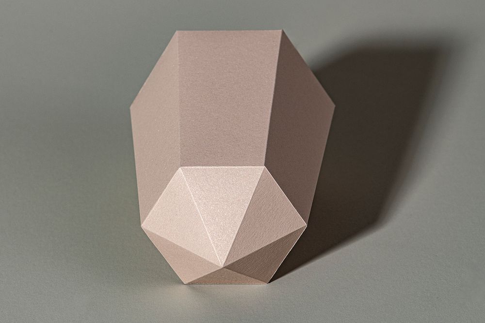 Pink hexagonal prism paper craft on a gray background