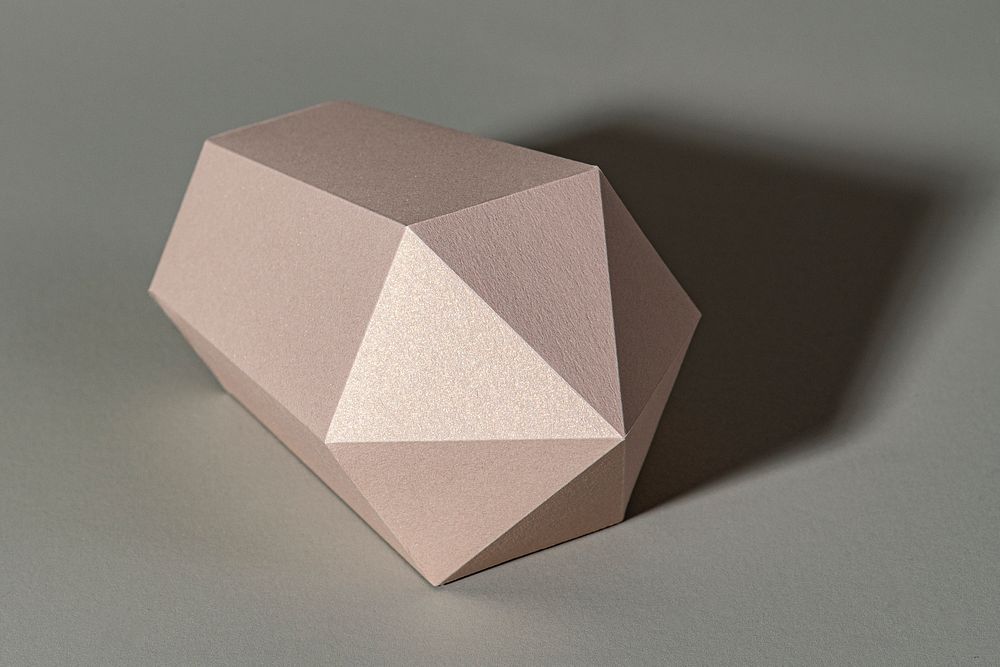 Pink hexagonal prism paper craft on a gray background