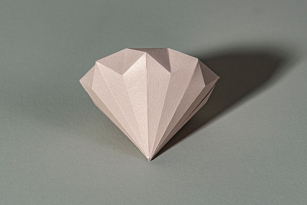 3D pink diamond shaped paper craft on a gray background