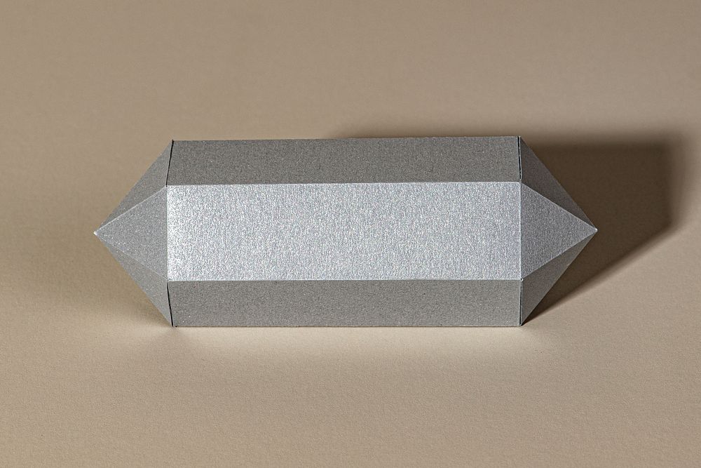 Silver hexagonal prism paper craft on a beige background