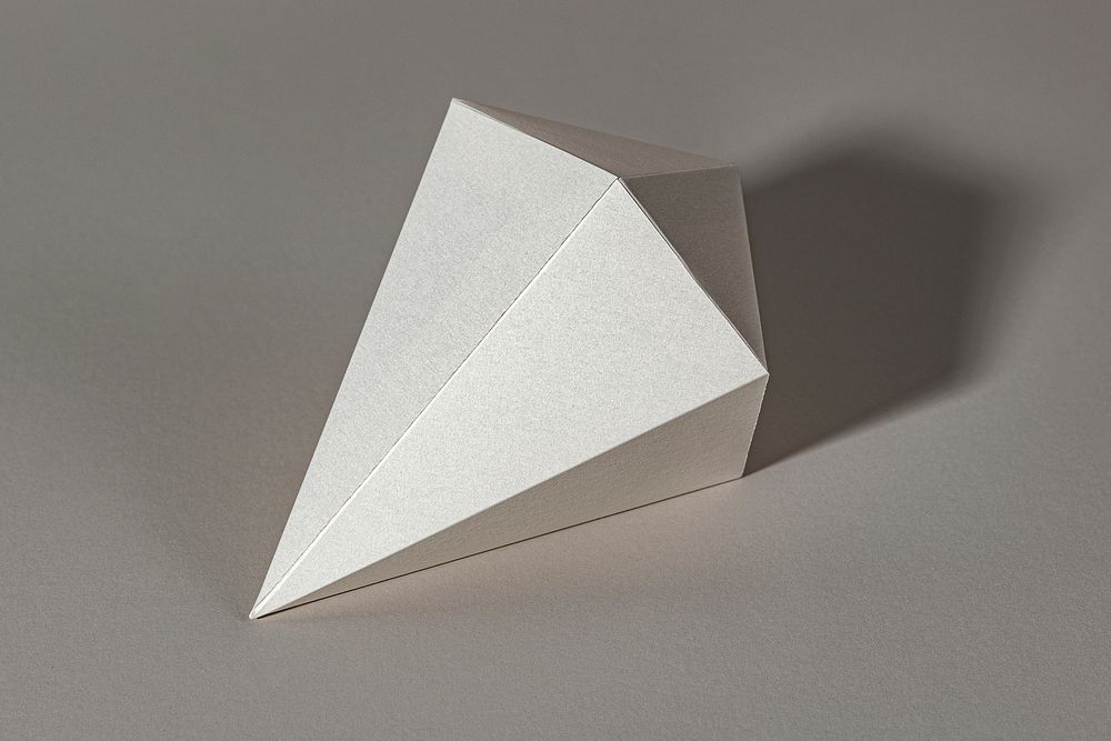 3D silver asymmetric hexagonal bipyramid paper craft on a gray background
