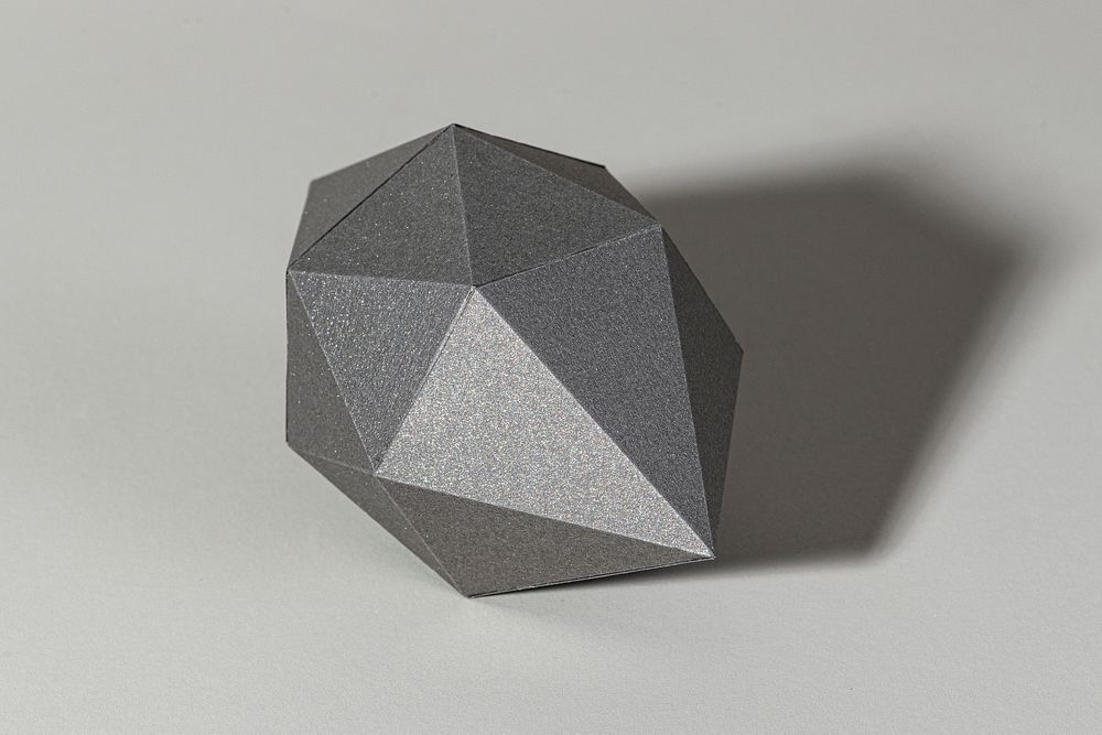 3D gray octahedral polyhedron shaped paper craft on a gray background