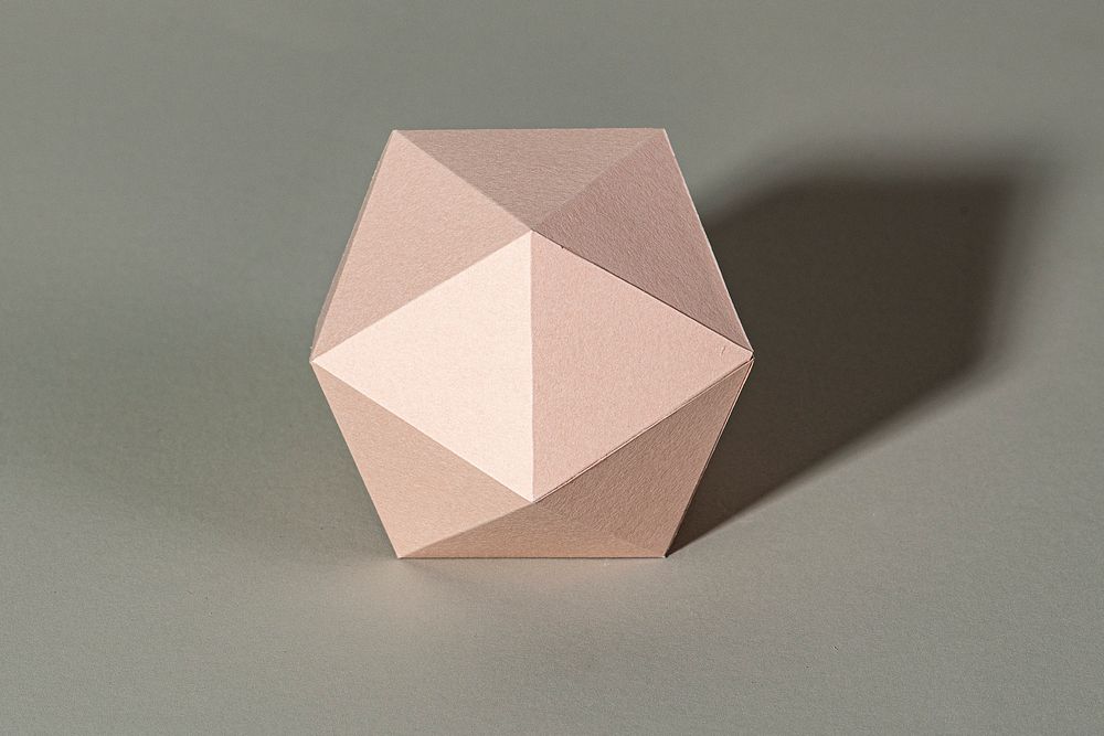 3D pink hexagon shaped paper craft on a gray background