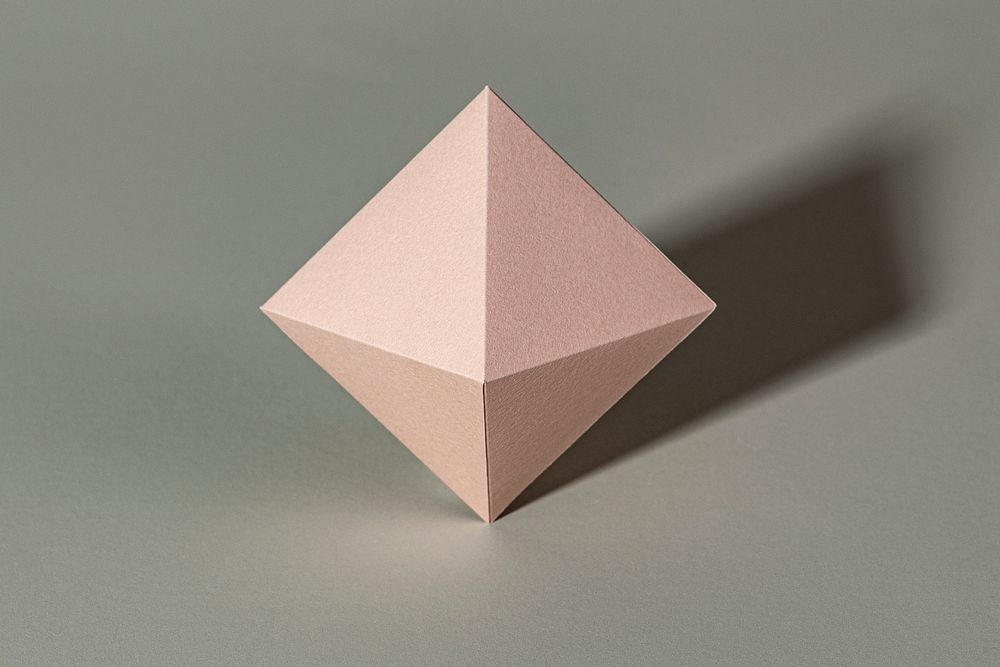 3D pink pyramid paper craft on a gray background