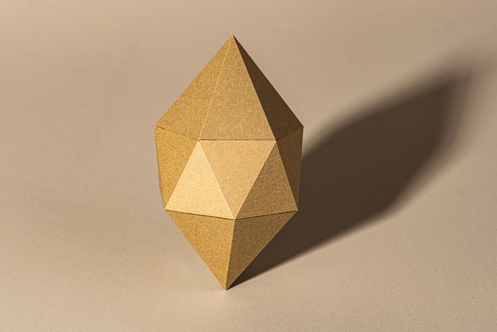 3D golden octahedral polyhedron shaped paper craft on a beige background