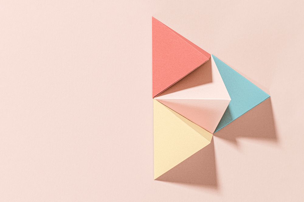 3D pastel pyramid paper craft on a pink background