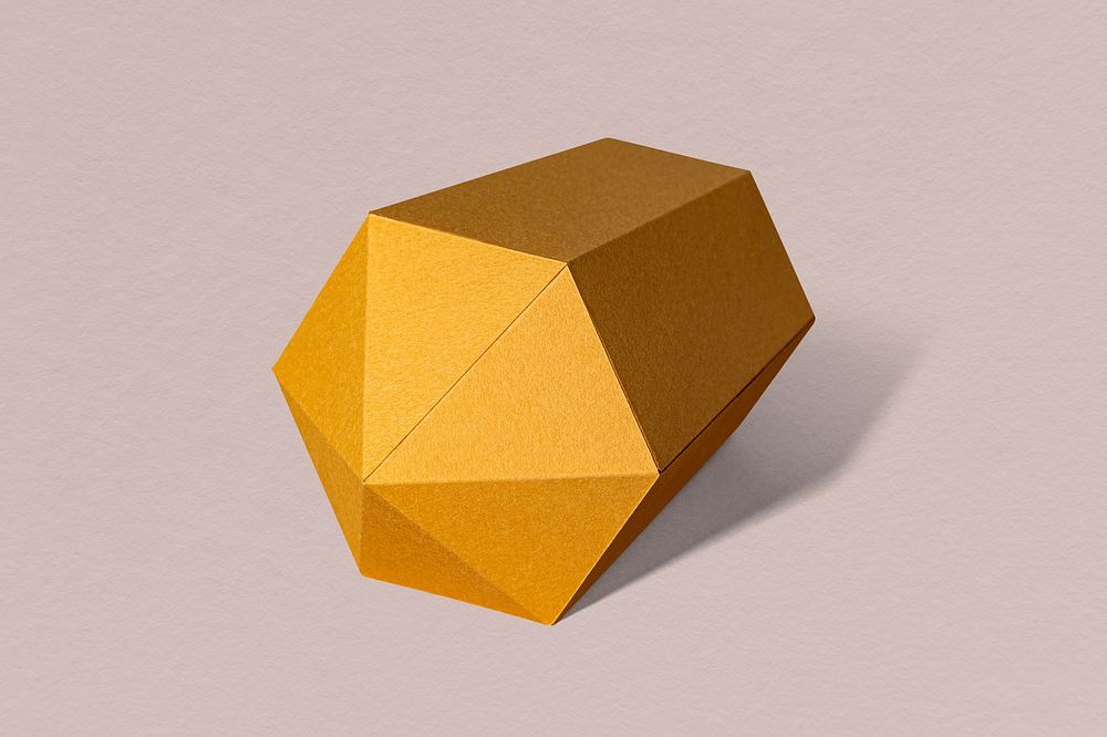 Golden hexagonal prism paper craft on a dull pink background