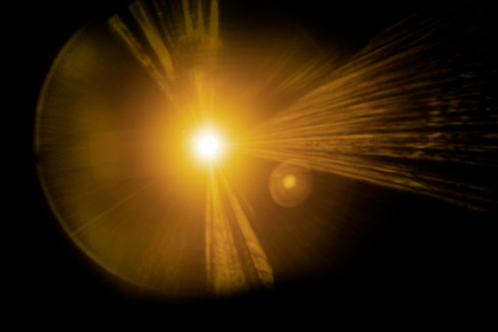 Yellow lens flare effect design element on a black background